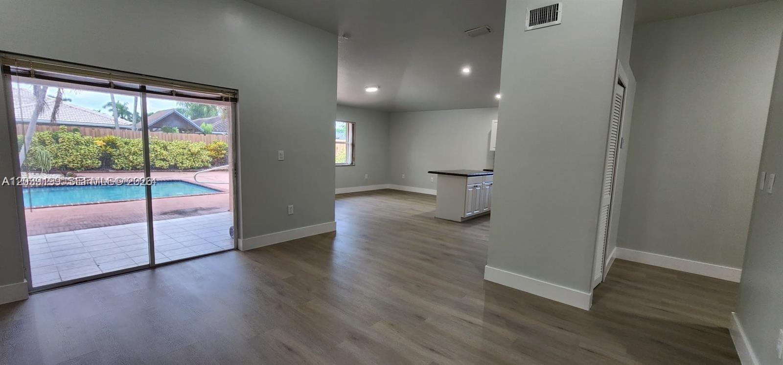 14817 Southwest 180th Street Miami, FL 33187 - Photo 3 of 15 a view of empty room with wooden floor and fan