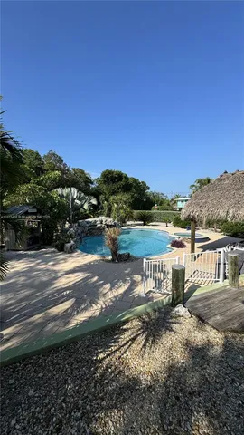 swimming pool view with plants and large trees