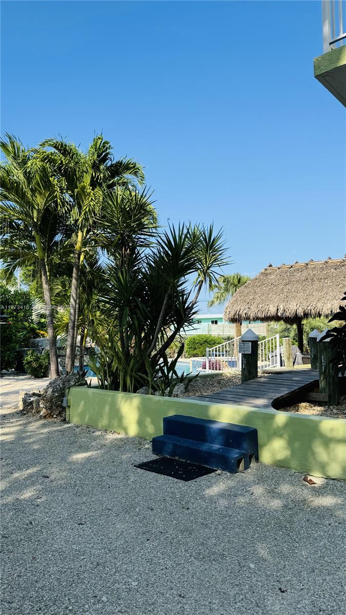 443 4th Road, Unit MAIN Key Largo, FL 33037 - Photo 29 of 31 a sign that is sitting in front of a house with a big yard