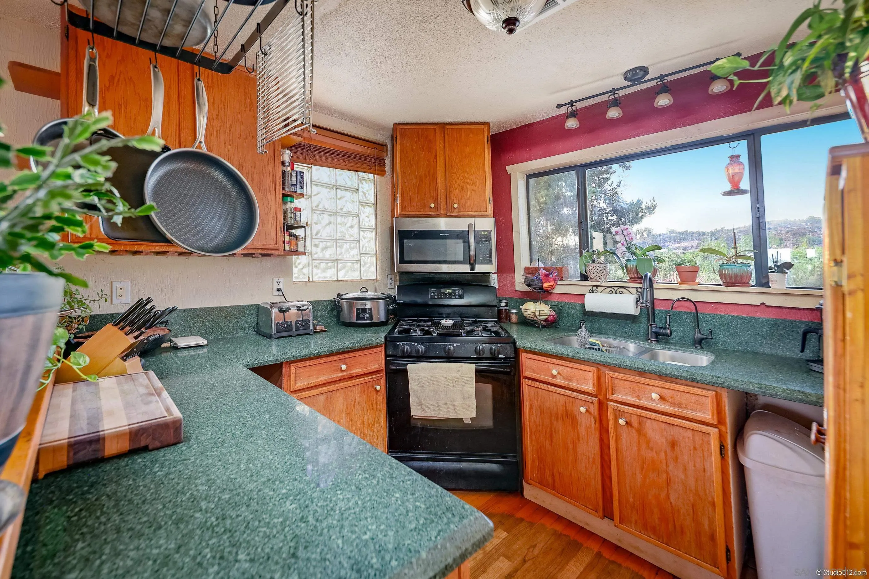 31141 Saddleback Road Valley Center, CA 92082 - Photo 10 of 23 an open kitchen with granite countertop a stove a sink and a wooden cabinets