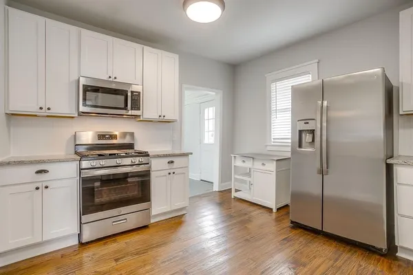 a kitchen with cabinets stainless steel appliances a sink and a window