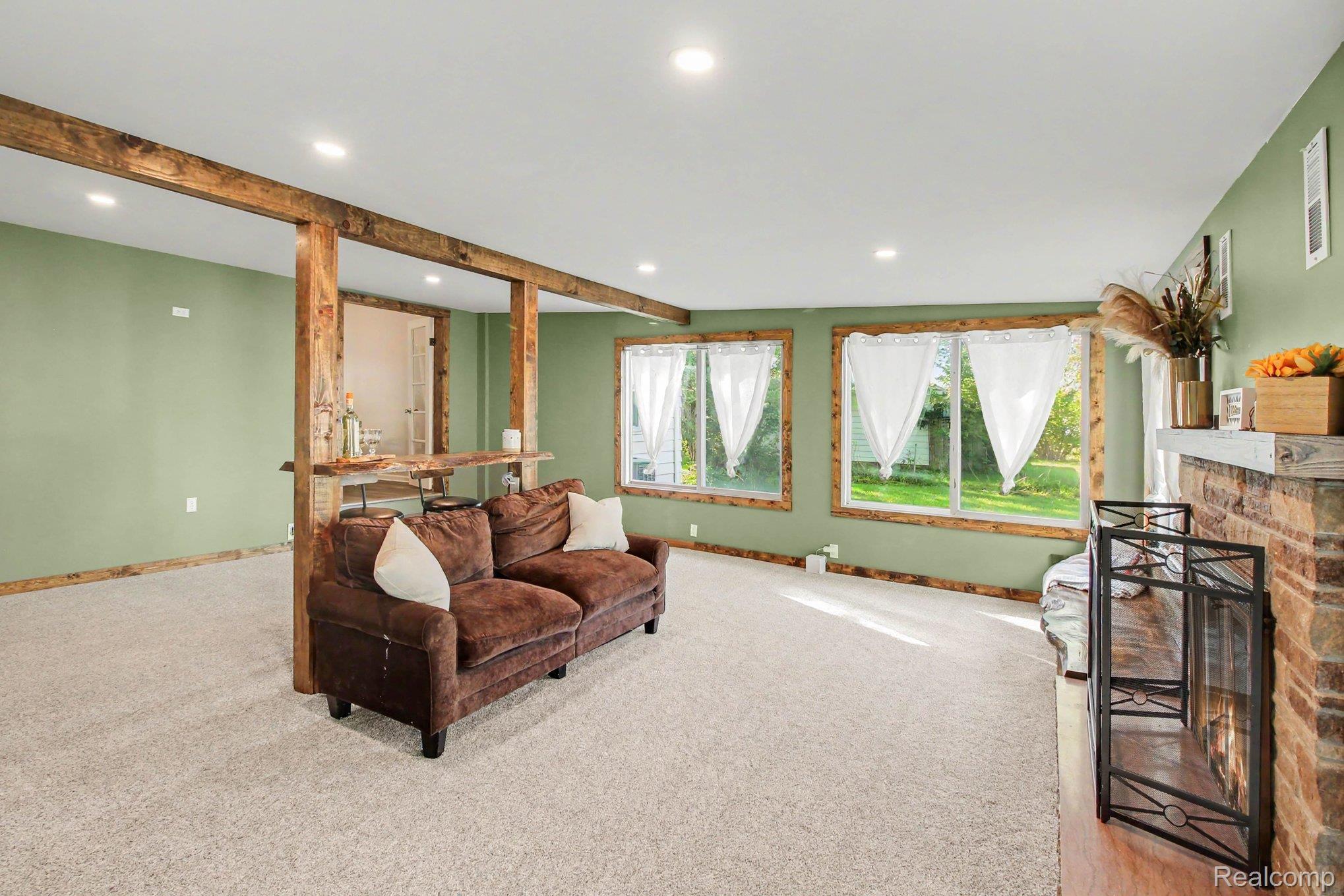 207 Elms Road Flushing, MI 48433 - Photo 13 of 30 Exposed wood beams, wood-framed windows, and light green wall finish