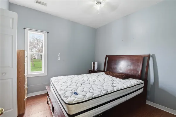 a bedroom with a bed and a flat tv screen on dresser