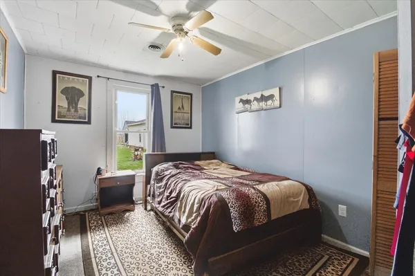 a bedroom with a bed couch and a window