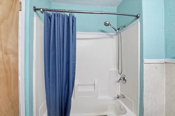 a bathroom with a shower and a bath tub