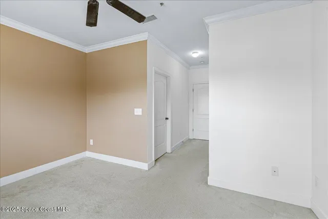 en empty room with closet and a chandelier fan