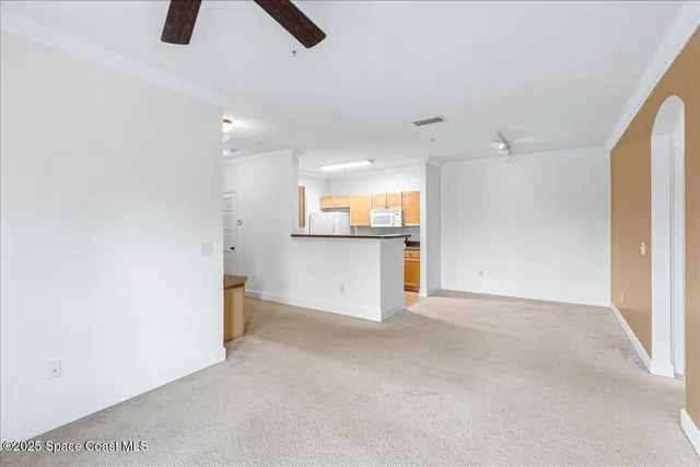 an empty room with windows and ceiling fan