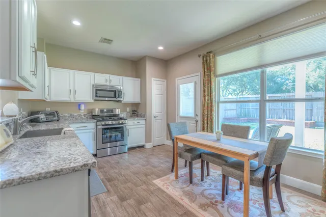 a kitchen with granite countertop kitchen island wooden cabinets and dining table