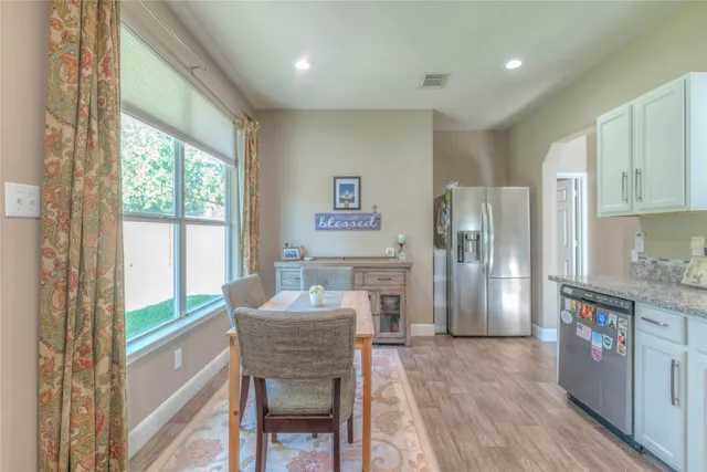 a kitchen with refrigerator a sink and chairs