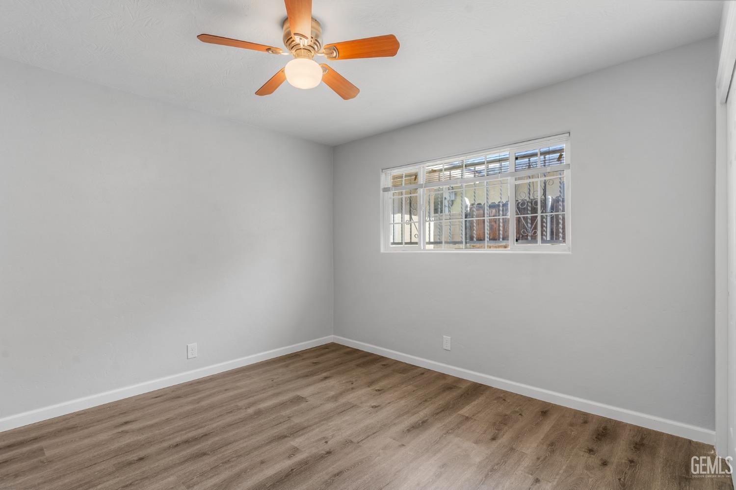 Undisclosed Address Bakersfield, CA 93305 - Photo 12 of 21 an empty room with wooden floor and windows