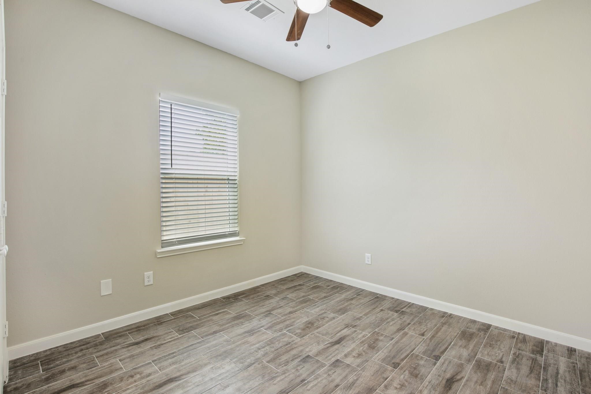 5911 Westover Street Houston, TX 77033 - Photo 17 of 21 an empty room with a window and a ceiling fan