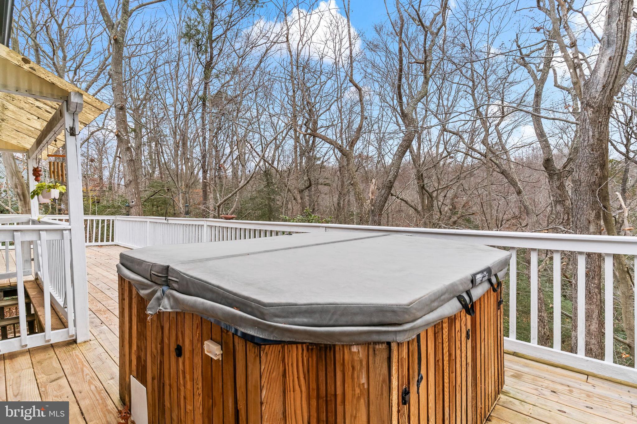 285 Red Cloud Road Lusby, MD 20657 - Photo 23 of 39 Serene deck with hot tub amid nature.