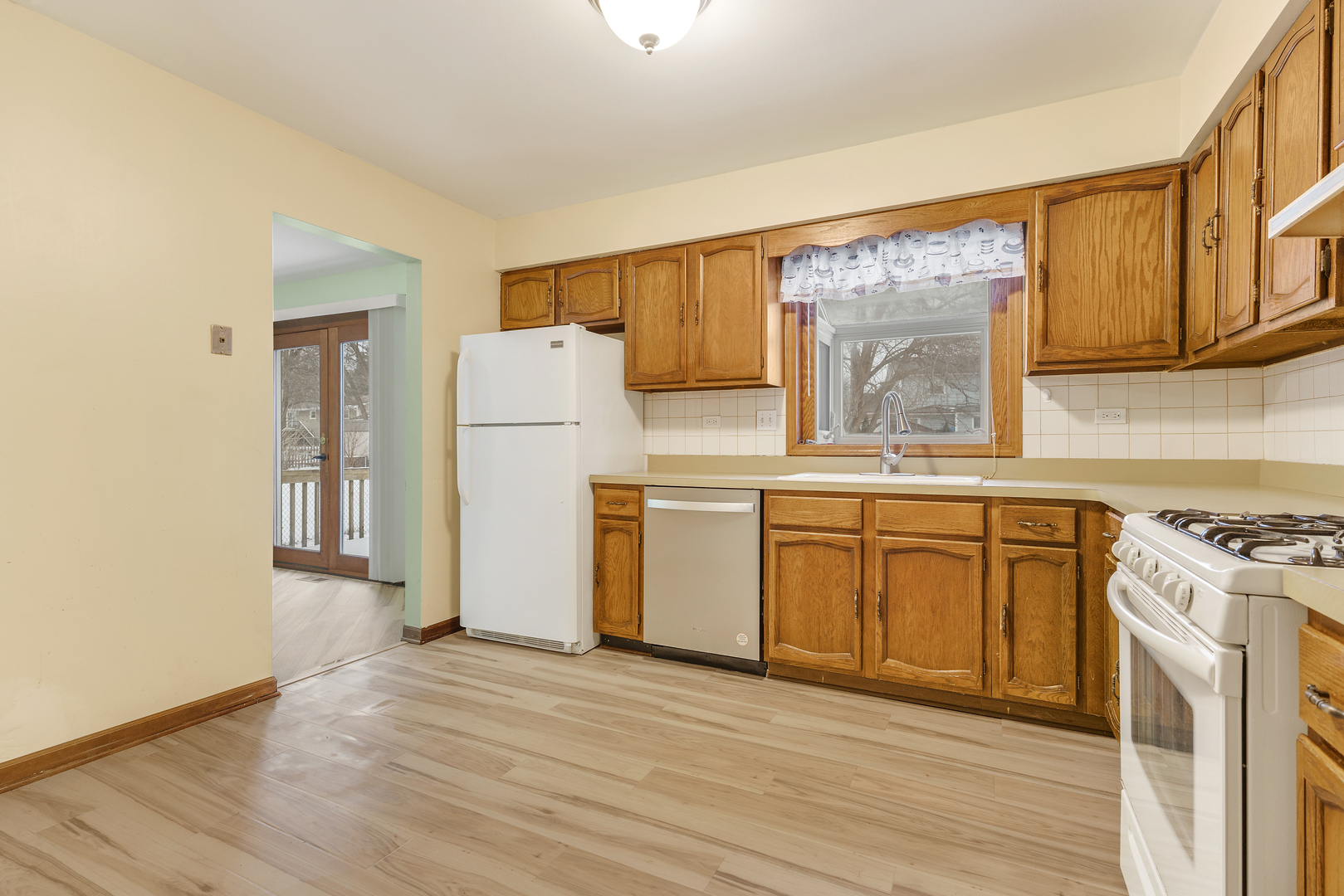 720 Ash Street Algonquin, IL 60102 - Photo 4 of 25 a kitchen with a white cabinets and wooden floor