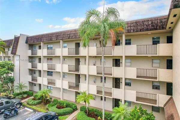 a front view of a building with a garden and plants