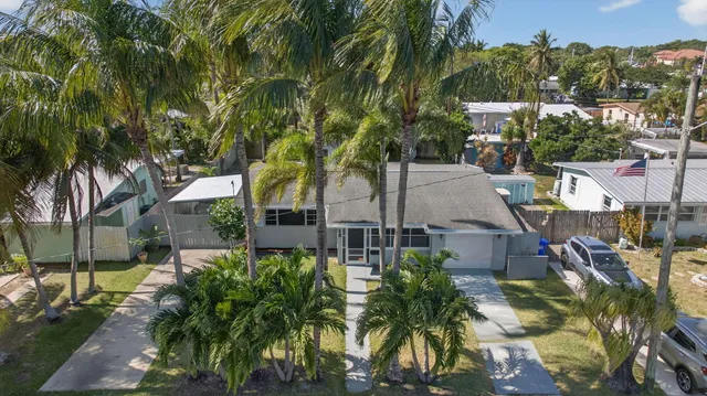 a view of a white house with a yard and plants