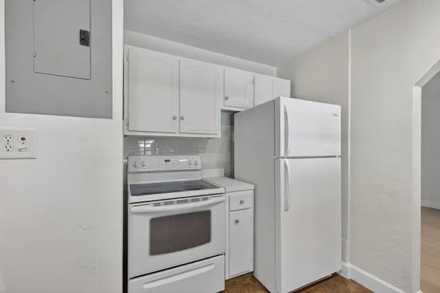 a kitchen with a white cabinets and a refrigerator