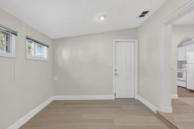 a view of an empty room with closet and a window