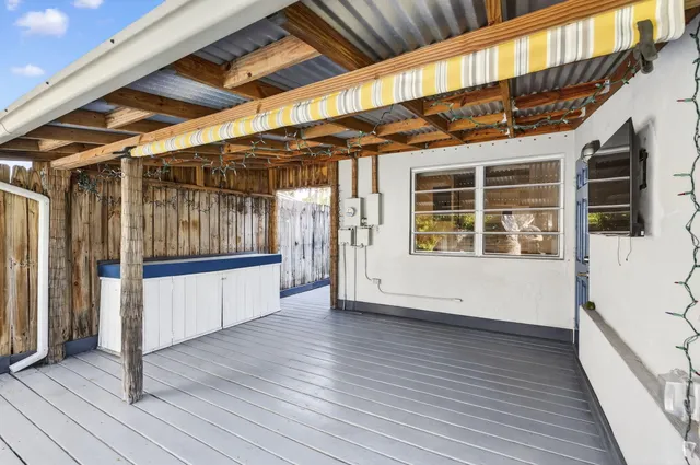 a view of an empty room with wooden floor and windows