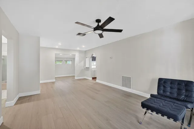 a living room with furniture and a ceiling fan