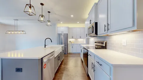 a kitchen with stainless steel appliances granite countertop a sink refrigerator and microwave
