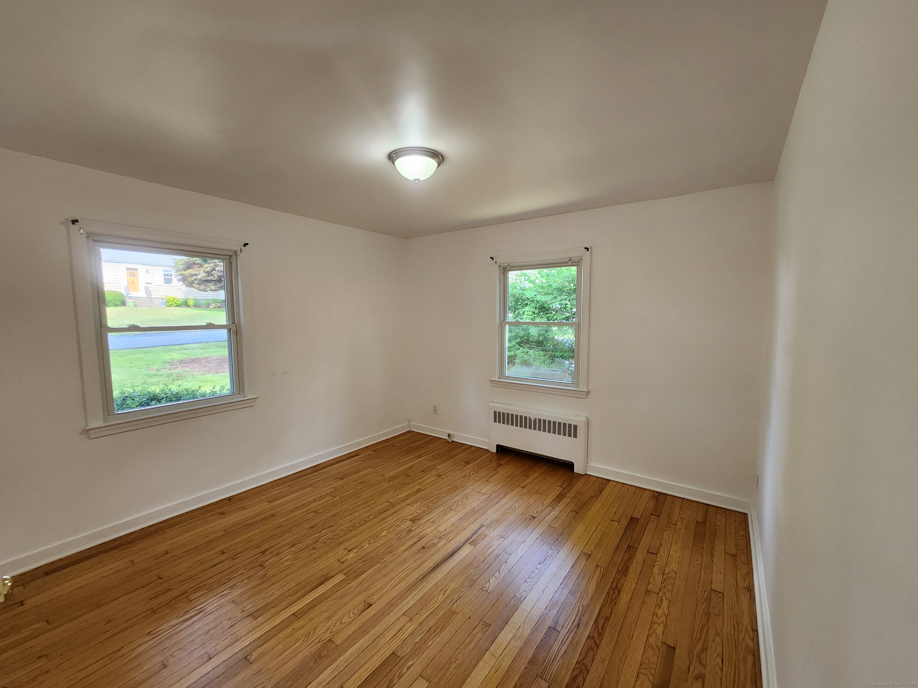 79 Honor Road West Haven, CT 06516 - Photo 12 of 36 an empty room with wooden floor and windows