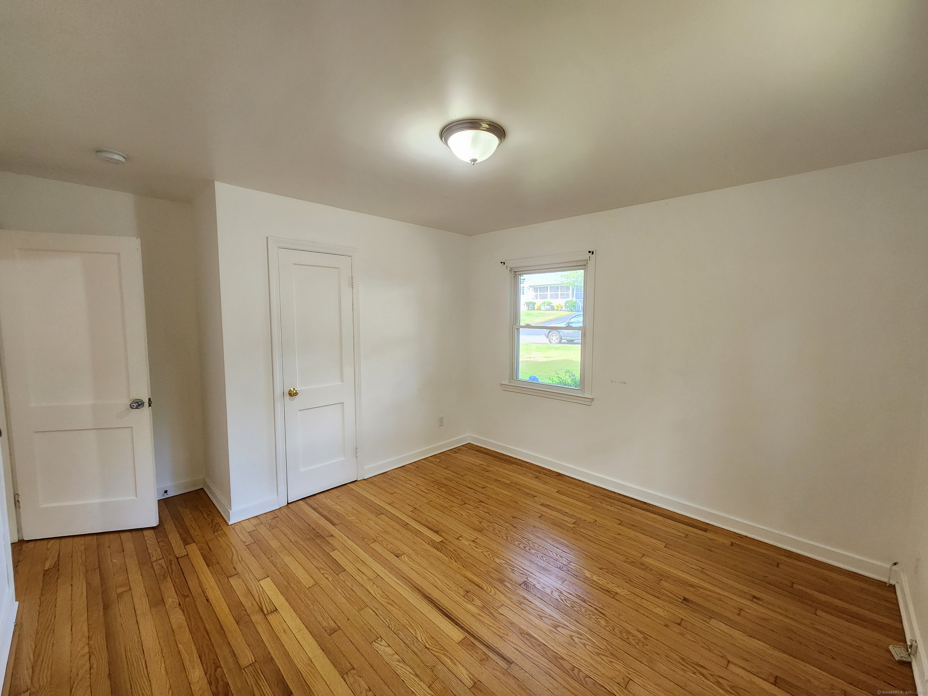 79 Honor Road West Haven, CT 06516 - Photo 13 of 36 a view of empty room with wooden floor and fan
