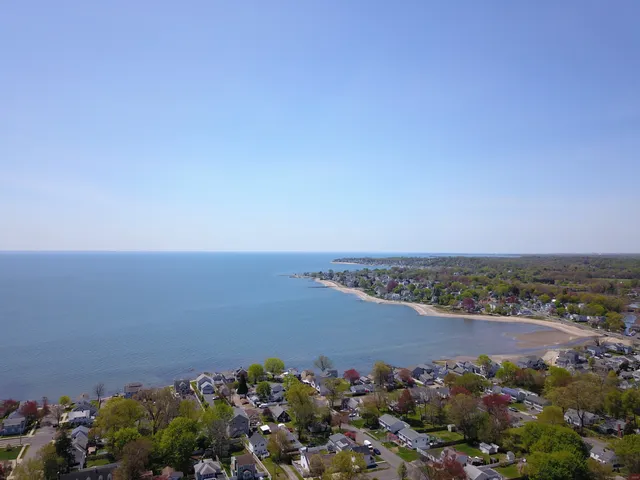 an aerial view of a house with a yard and lake view