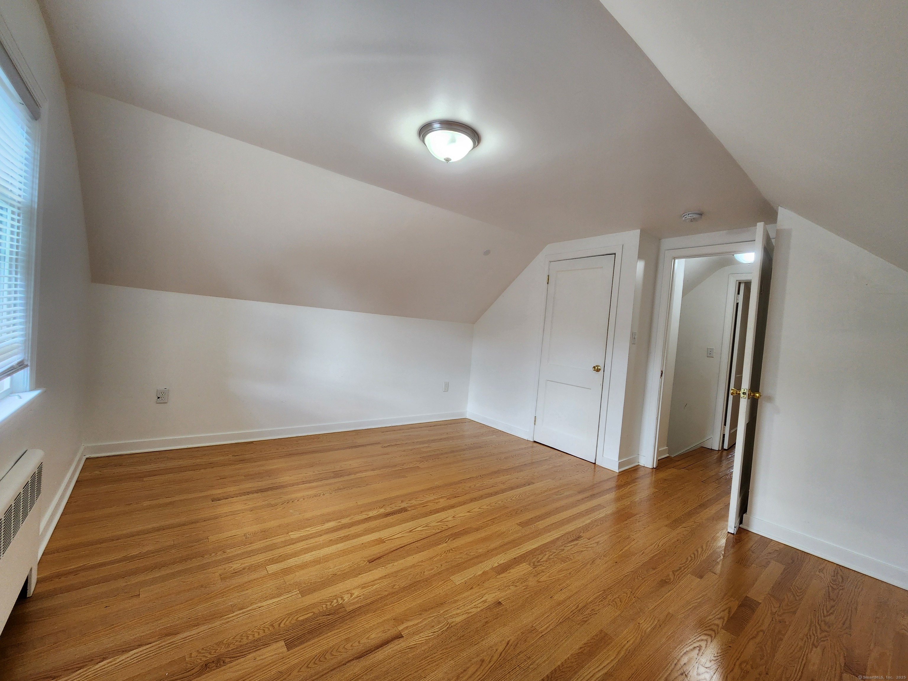 79 Honor Road West Haven, CT 06516 - Photo 22 of 36 a view of an empty room with wooden floor and a window