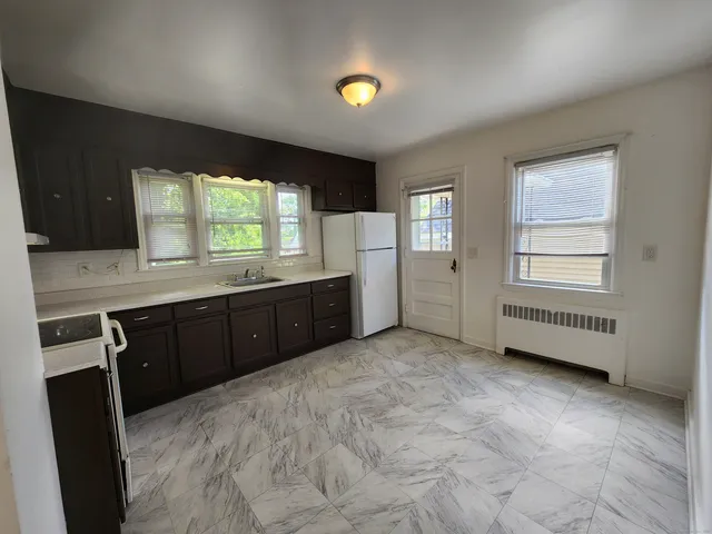a kitchen with a refrigerator and a stove top oven