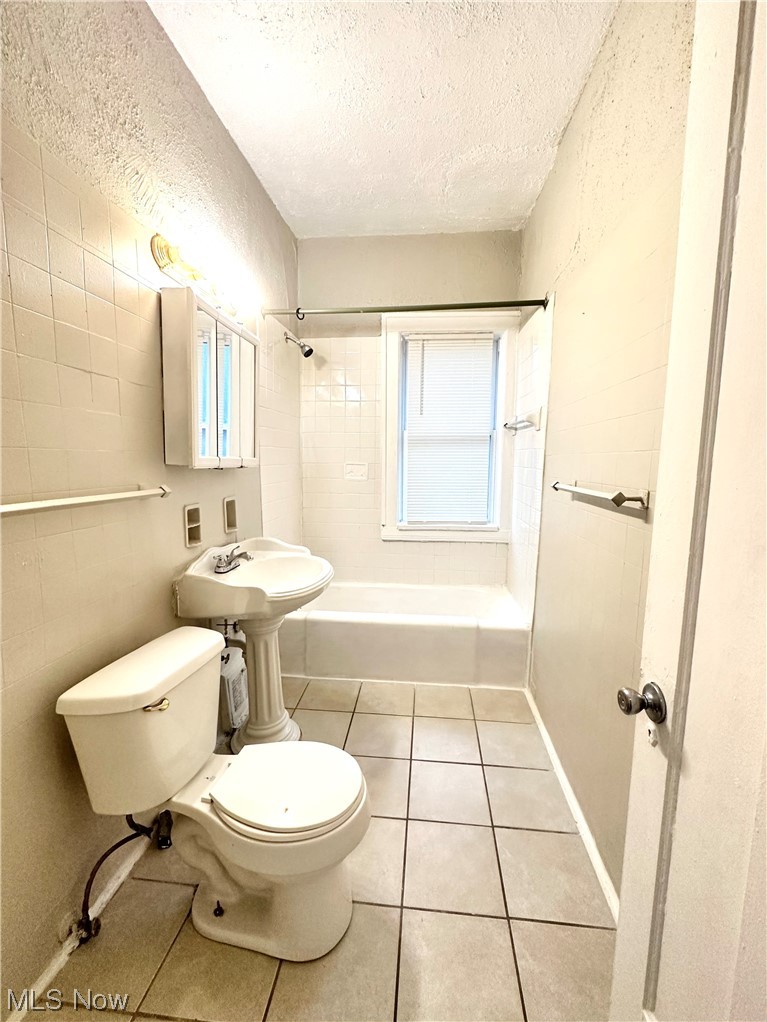 3228 Berkeley Road Cleveland, OH 44118 - Photo 15 of 26 Full bathroom featuring tiled shower / bath, toilet, tile flooring, and a wealth of natural light
