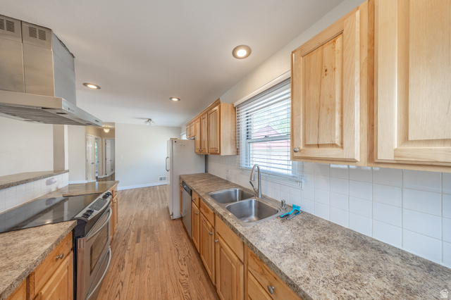 193 Locust Street Clearfield, UT 84015 - Photo 9 of 29 Galley kitchen featuring wood-finish cabinetry, stainless steel appliances, and abundant counter space