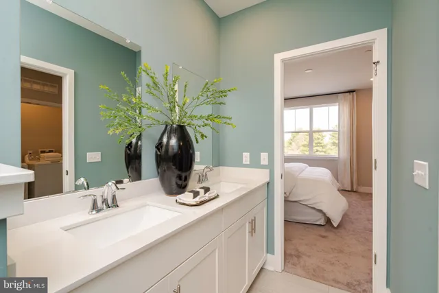 a en suite bathroom with a granite countertop sink and a mirror