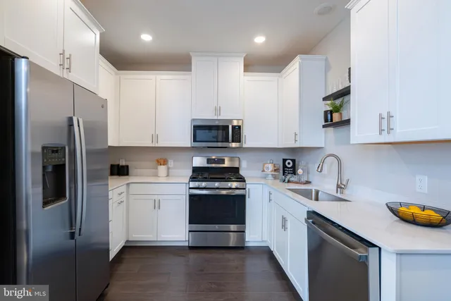 a kitchen with stainless steel appliances granite countertop a refrigerator stove and sink