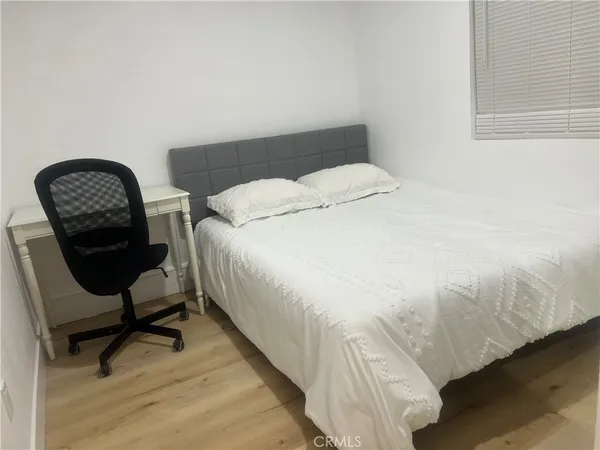 a bedroom with a bed a desk and chair