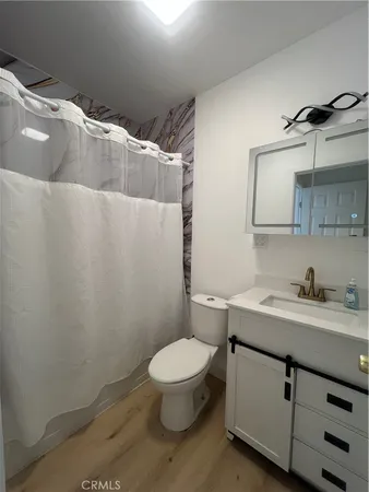 a bathroom with a granite countertop toilet sink and mirror