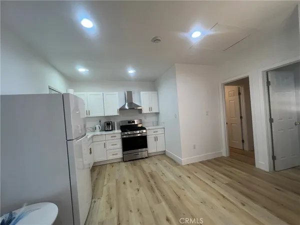 a kitchen with stainless steel appliances a refrigerator and a stove top oven