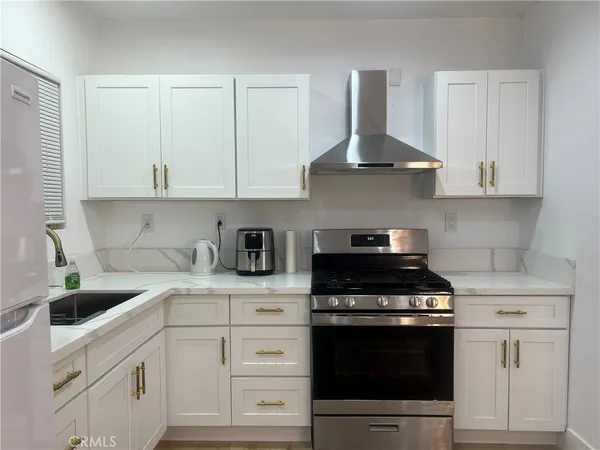 a kitchen with white cabinets and appliances