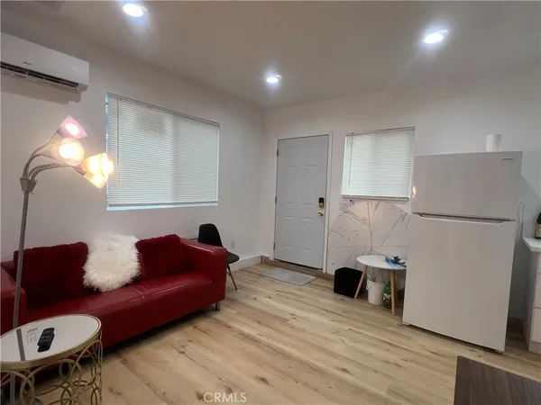 a living room with furniture and a refrigerator