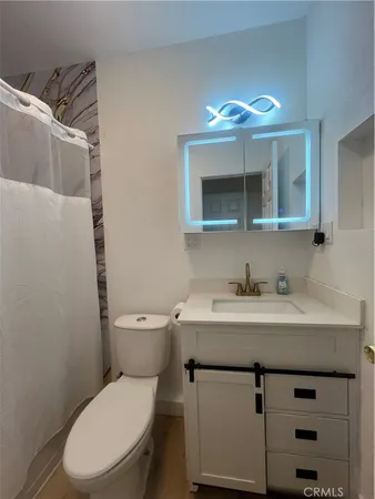 a bathroom with a toilet a sink and mirror