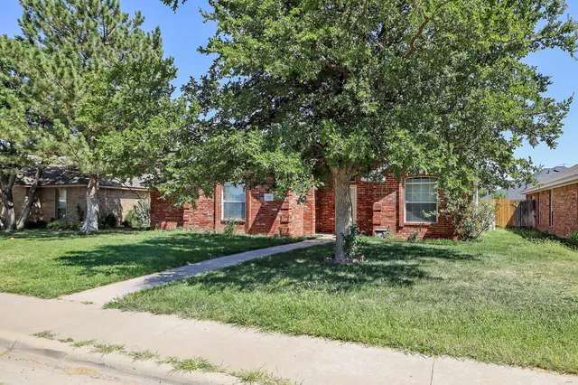 a couple of flower plants sitting in front of a house