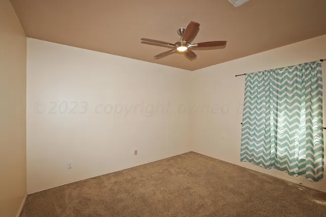 a view of a room with window and ceiling fan