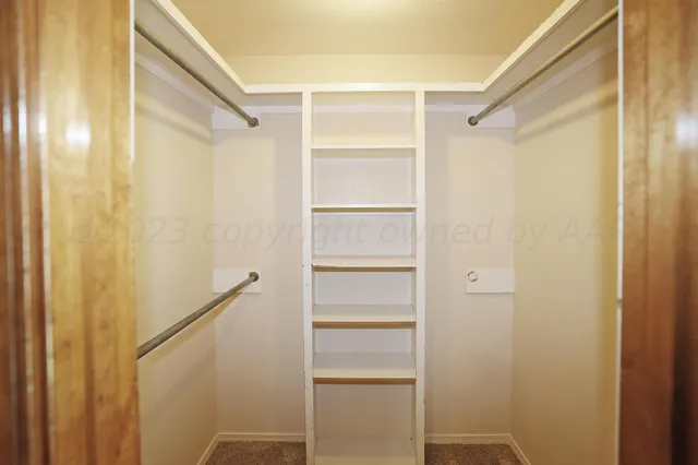 a view of walk in closet with empty racks