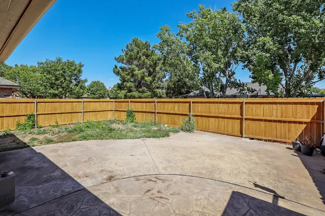 a view of backyard with wooden fence