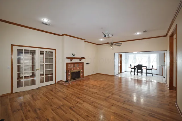a view of empty room with wooden floor and fireplace