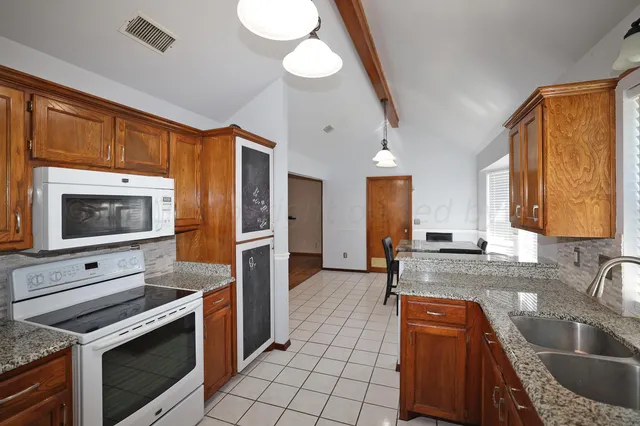 a kitchen with stainless steel appliances granite countertop a sink and a stove