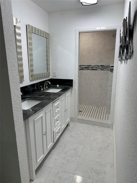 17067 Northwest Gainesville Road Reddick, FL 32686 - Photo 13 of 25 a bathroom with a granite countertop sink a mirror and a shower