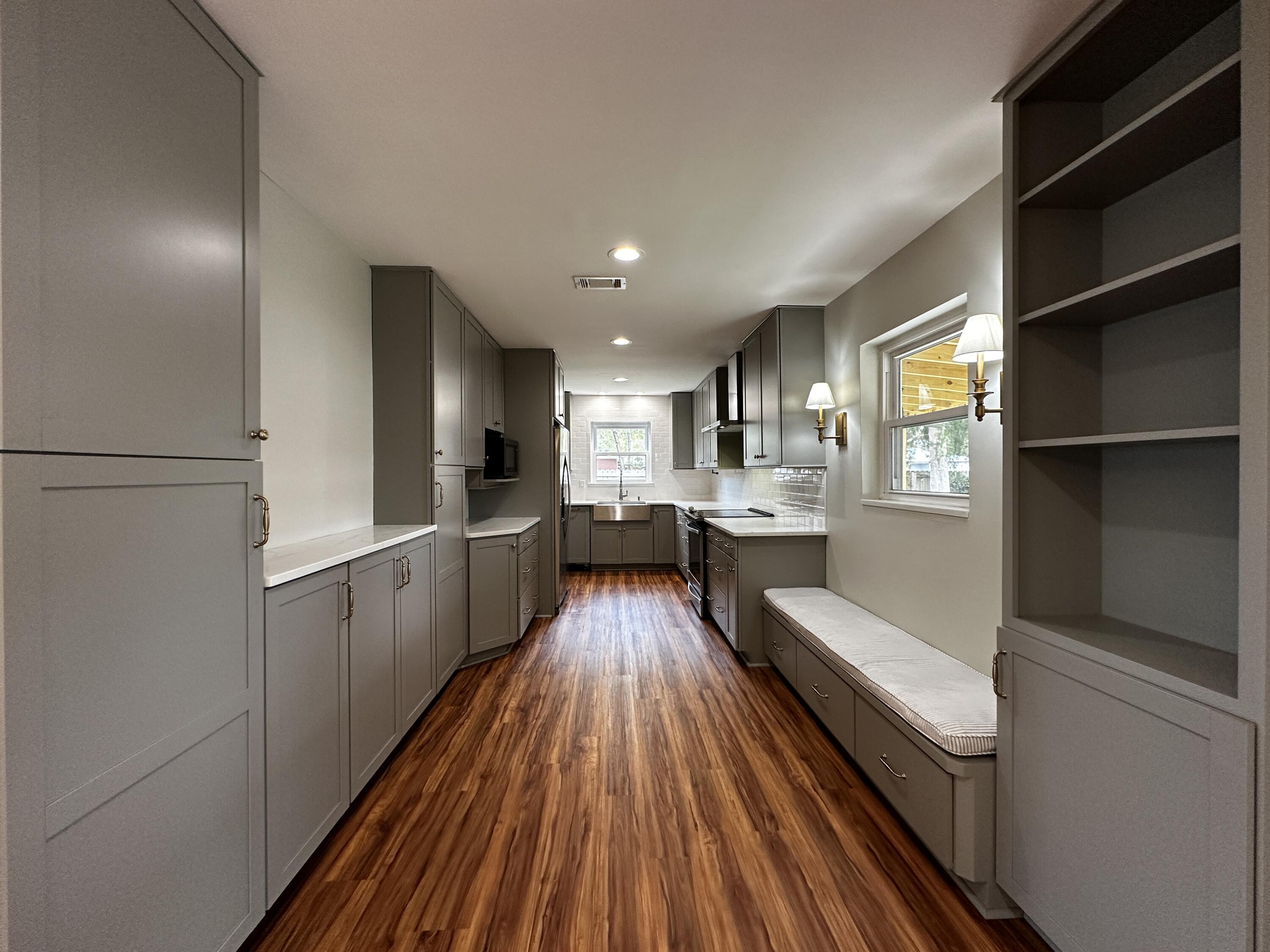 a kitchen with a refrigerator and wooden floor