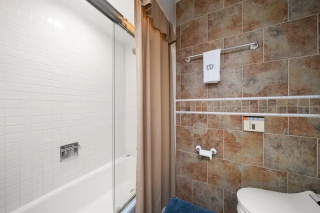 a bathroom with a toilet and a shower