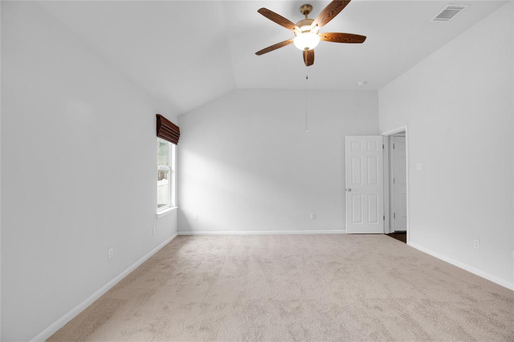 281 Hutton Kyle, TX 78640 - Photo 28 of 37 An airy bedroom with a vaulted ceiling and a functional ceiling fan for comfort.