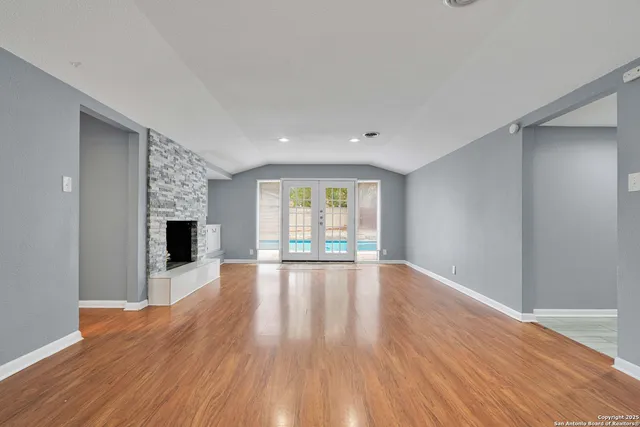 a view of empty room with wooden floor and fireplace
